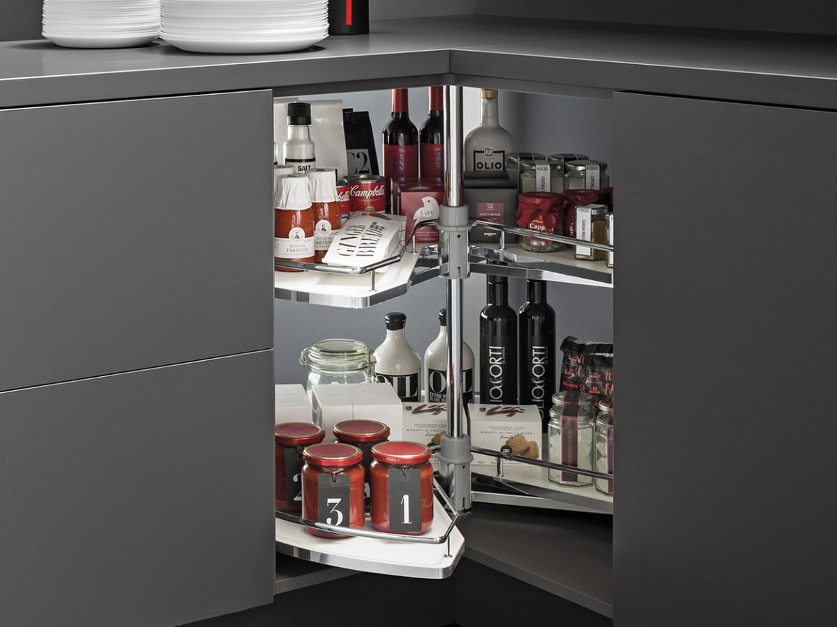 Corner cabinet with a swivel carousel organizer holding various condiments and jars.